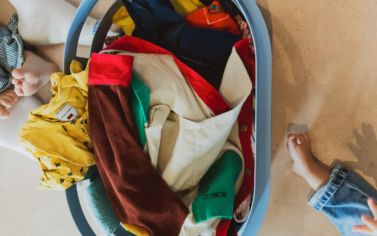 Wasmand met kleurrijke kinderkleding – de was doen met kinderen
