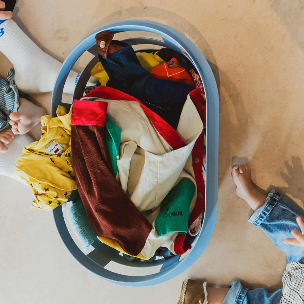 Wasmand met kleurrijke kinderkleding – de was doen met kinderen